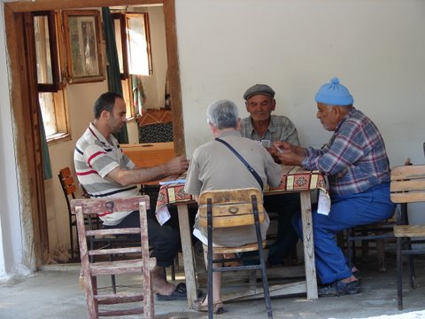 villagers - men play a game of cards at the cafe